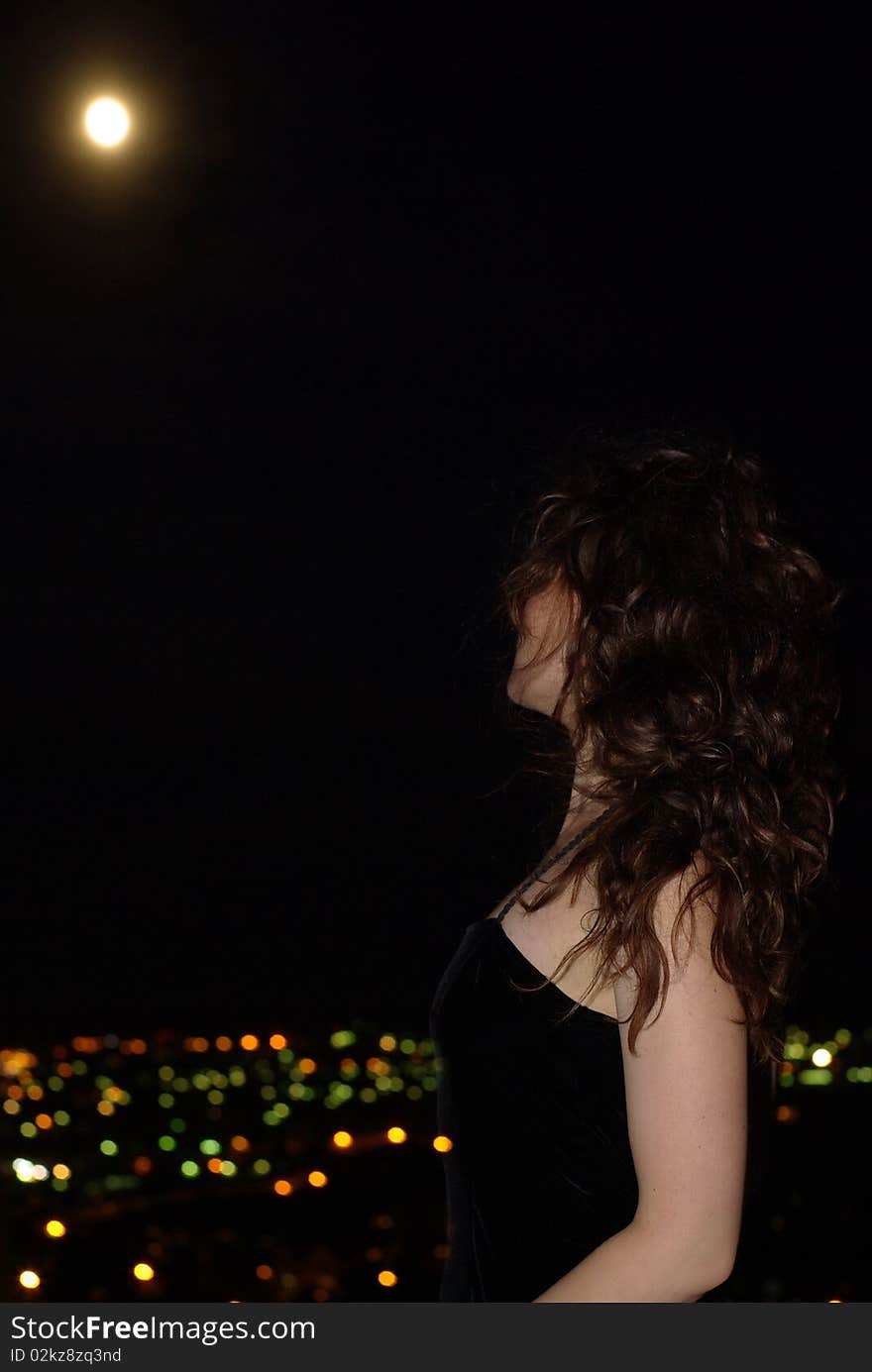 Female in a little black dress under full moon. Female in a little black dress under full moon