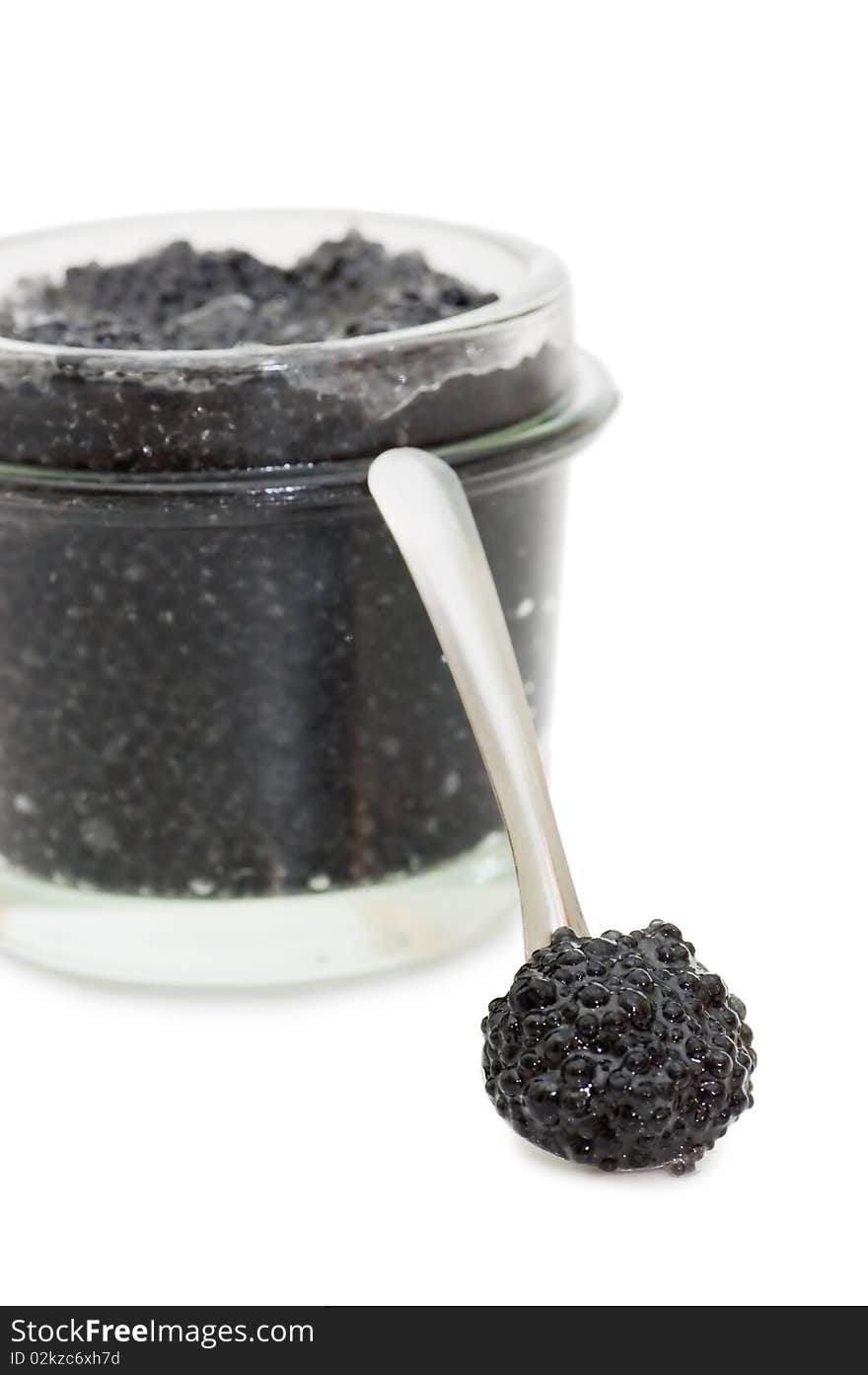 Black caviar in a glass jar on a white background