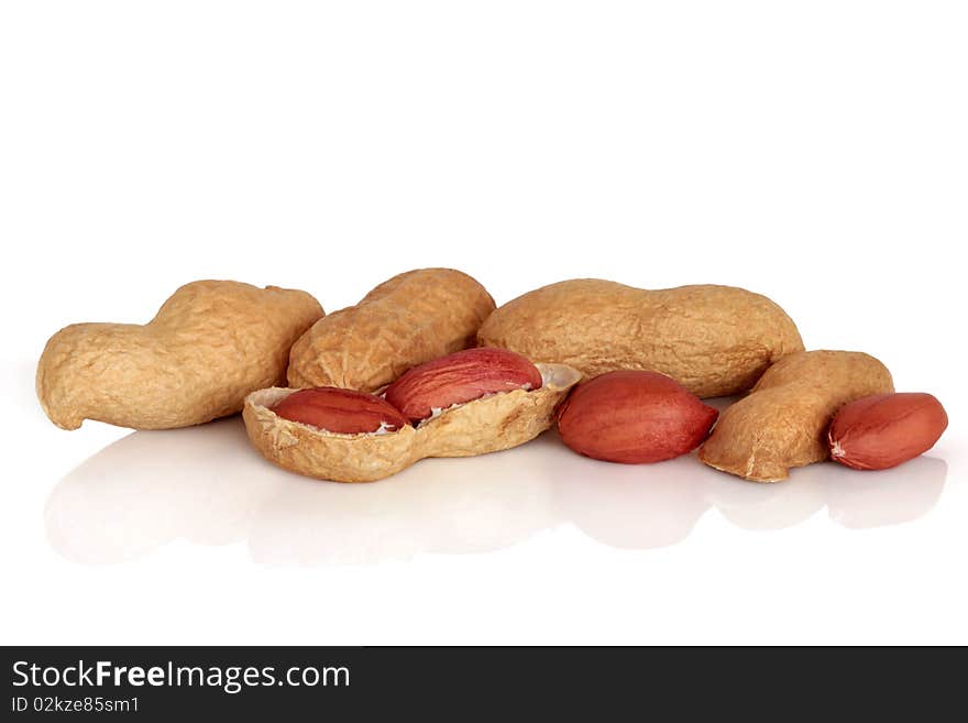 Peanuts in shells and cracked open, isolated over white background with reflection. Also known as monkey nuts.