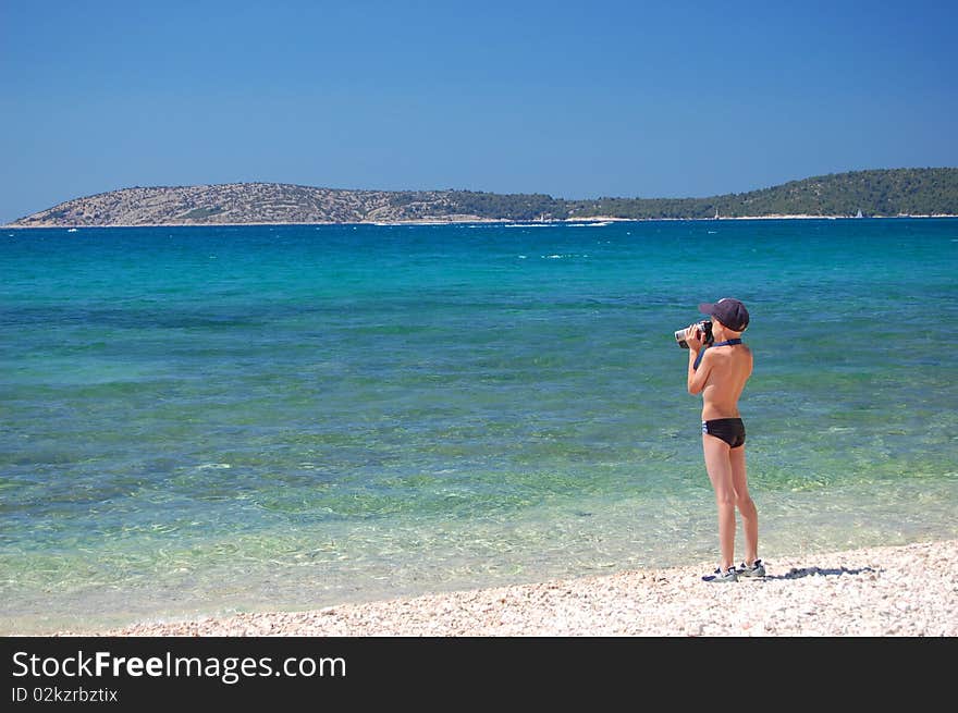 A small boy is making a video of croatian adriatic sea. A small boy is making a video of croatian adriatic sea