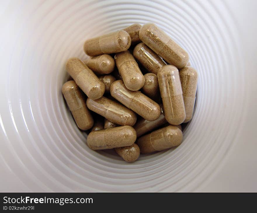 Drug pills in a white plastic glass