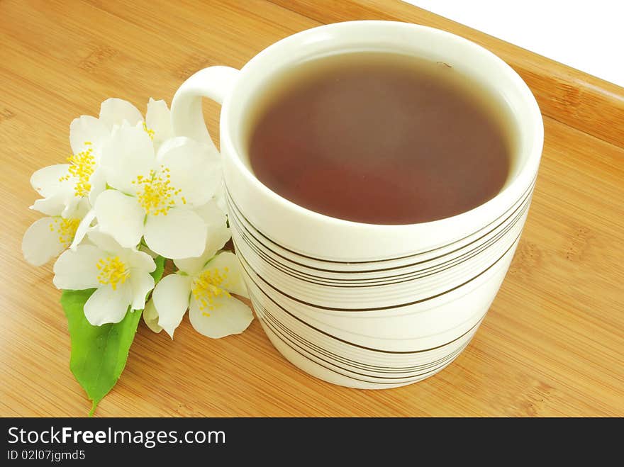 Mug of jasmine tea on a wooden tray