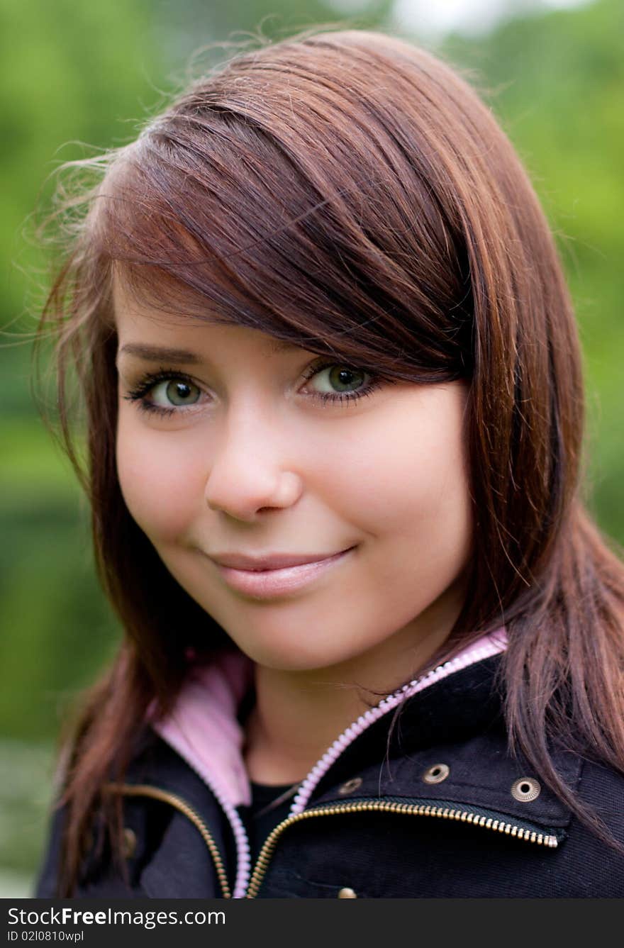 Portrait of the beautiful girl outdoors on the green defocused background. Portrait of the beautiful girl outdoors on the green defocused background