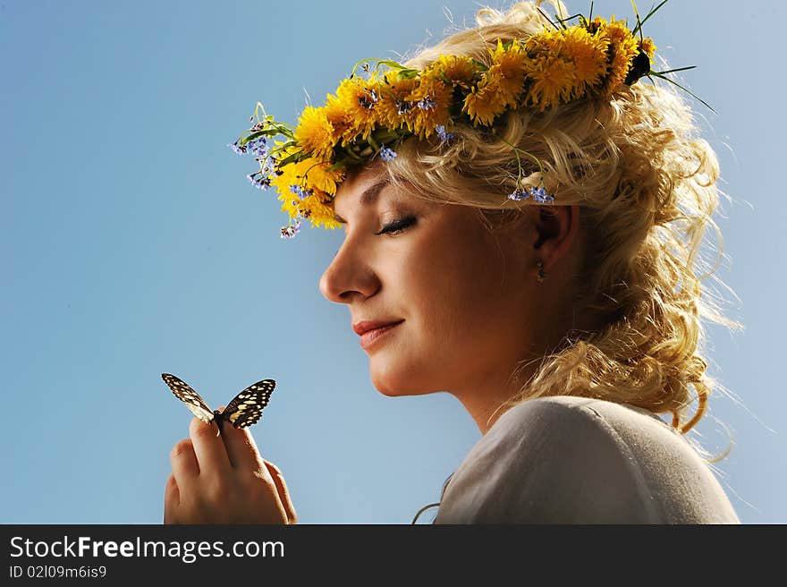 Lovely woman with a butterfly over blue sky