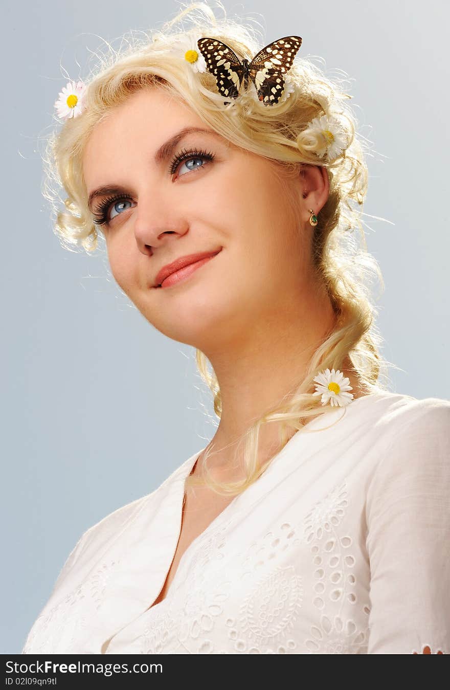 Lovely woman with a butterfly over blue sky