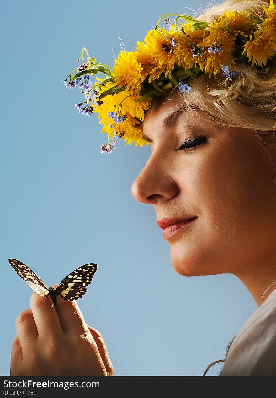 Lovely woman with a butterfly over blue sky