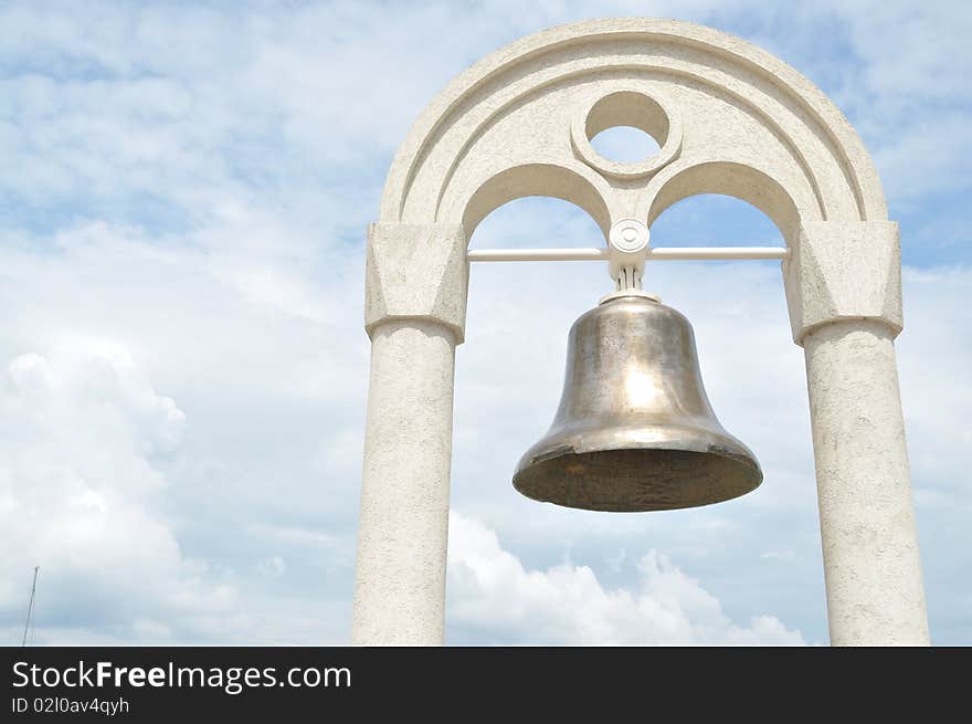 The old bell in the background of the sky,hanging on the arch. The old bell in the background of the sky,hanging on the arch