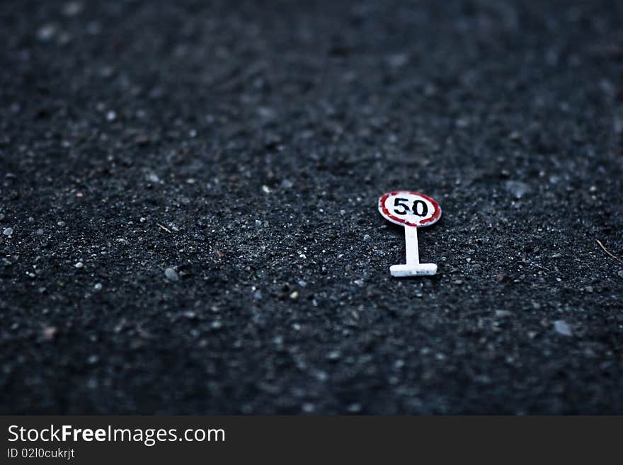 Speed limit sign made from toys and now lying ont the ground