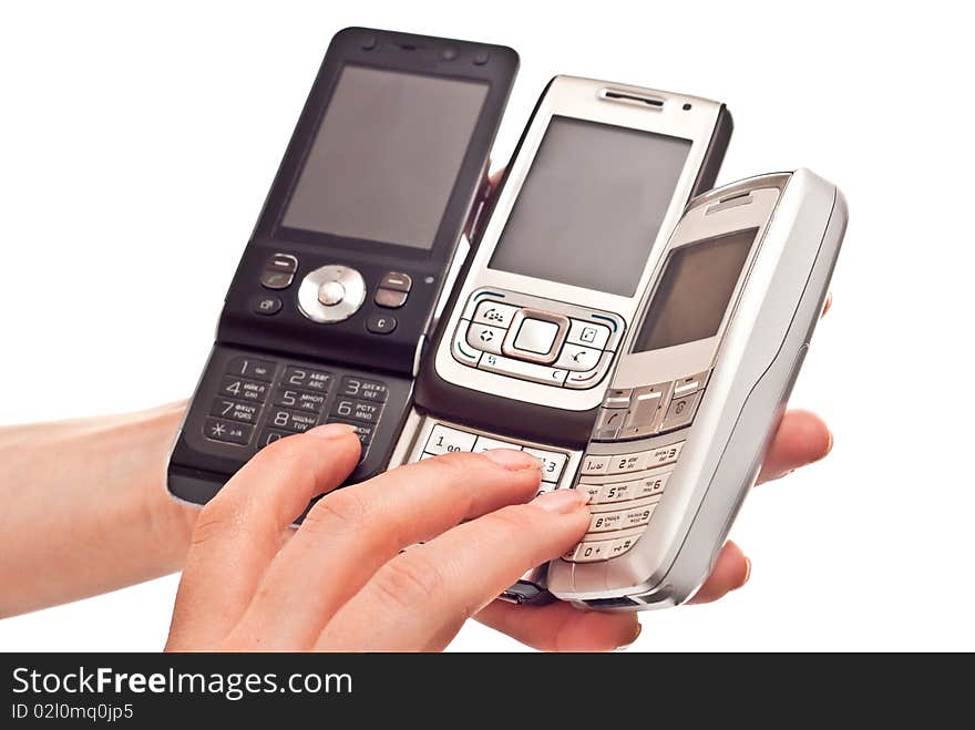 Three mobile phones in woman's hand. Isolated on white