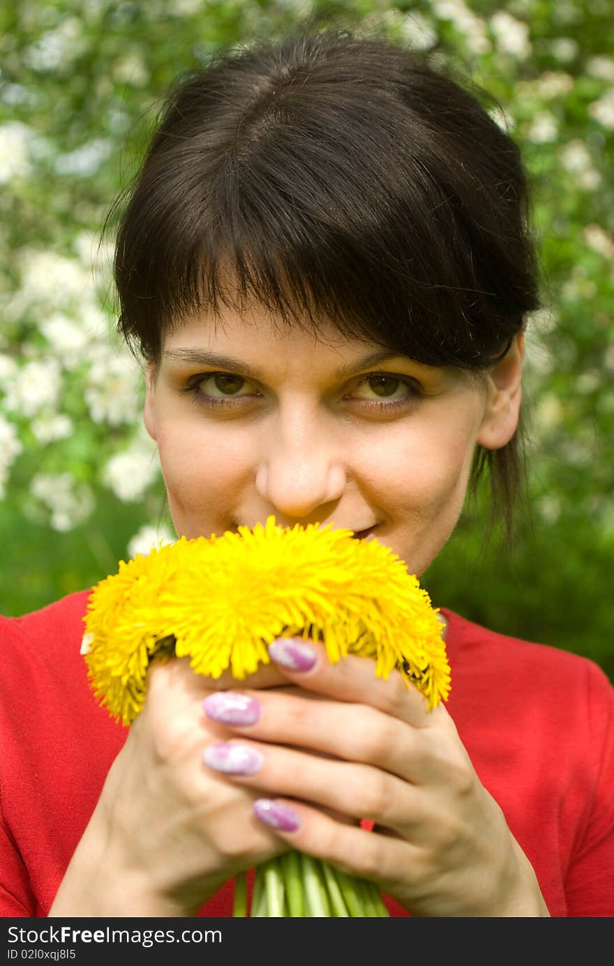 Beautiful smiling girl with bouquet of dandelions in a spring garden. Beautiful smiling girl with bouquet of dandelions in a spring garden