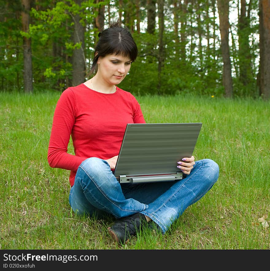 Beautiful girl with a laptop on forest glade. Beautiful girl with a laptop on forest glade