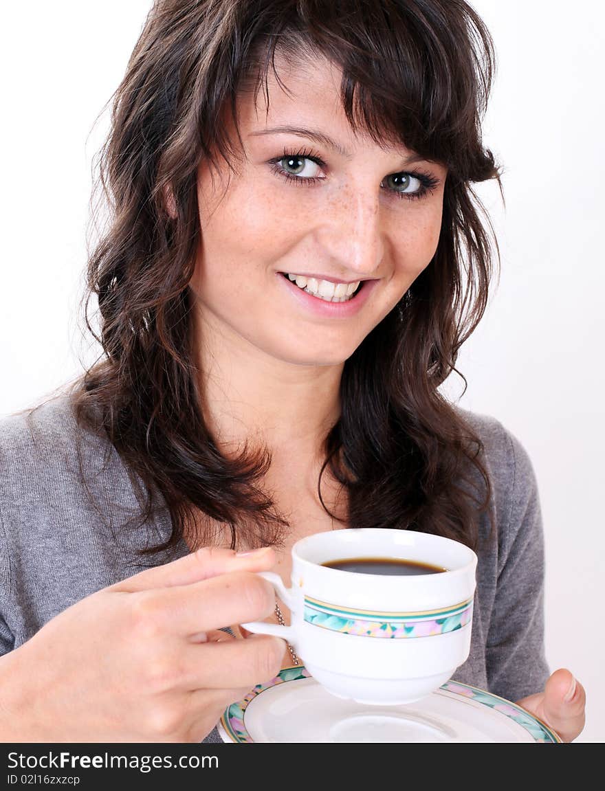 Young girl is drinking traditional pure black cup of coffee in front of a white background. Young girl is drinking traditional pure black cup of coffee in front of a white background