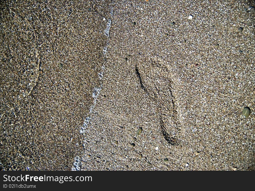 Sand stones with footprint and water wave