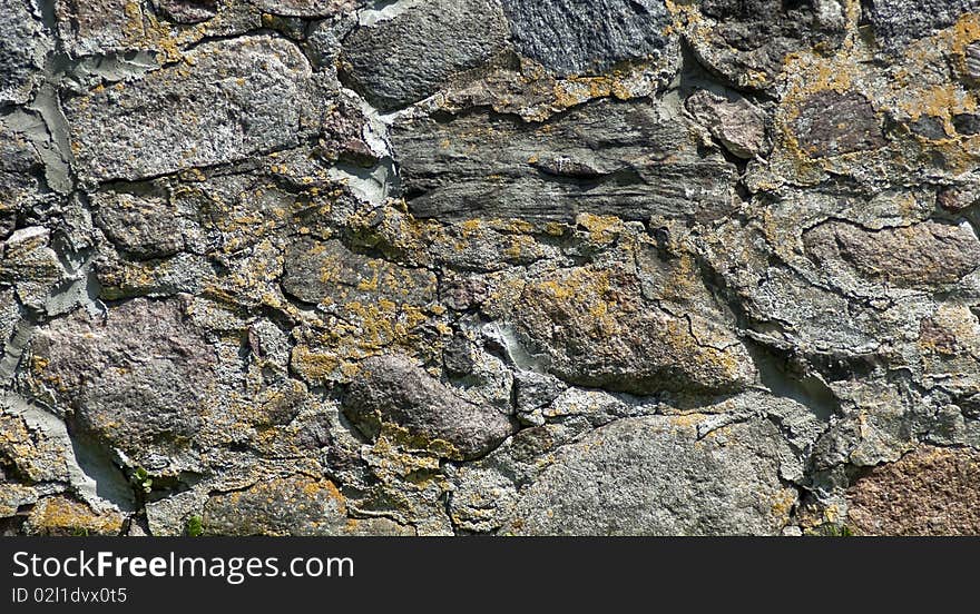 A stone wall overgrown with moss