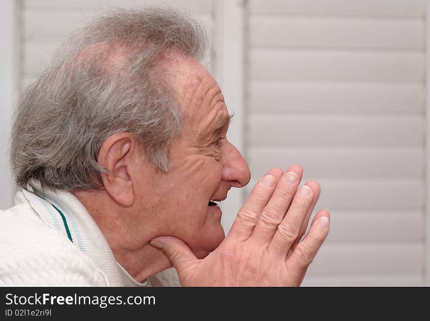 Smiling elderly man resting his head on hands profile closeup