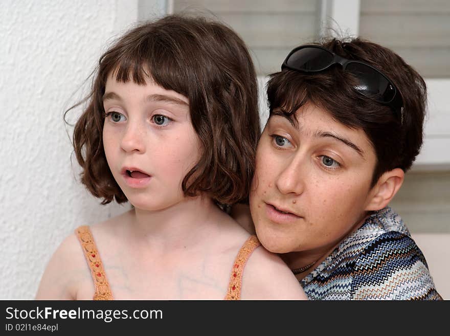 Mother and cute little daughter watch TV in great concentration. Mother and cute little daughter watch TV in great concentration