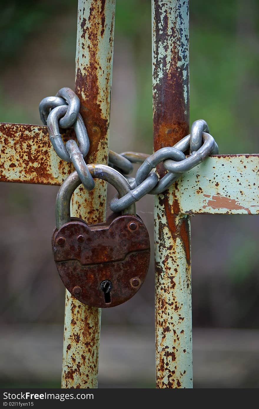 Old rusty gates closed wiyh chain and padlock. Old rusty gates closed wiyh chain and padlock