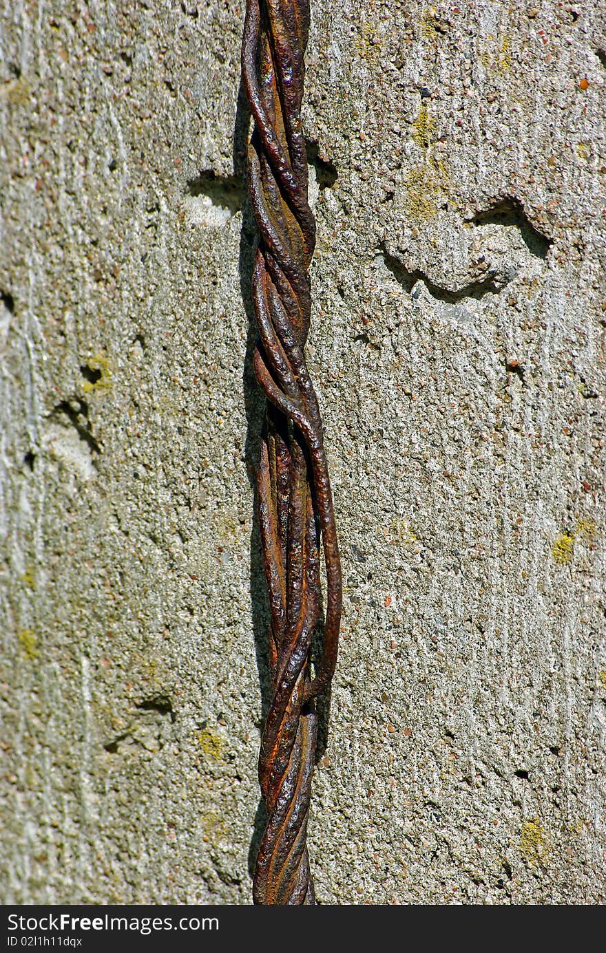 Old rusty rope of iron wires on concret wall background