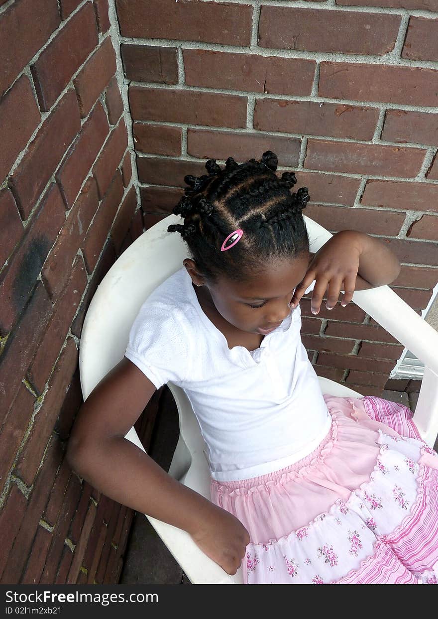 A young girl looks down as though she is unsure of what to do. A young girl looks down as though she is unsure of what to do