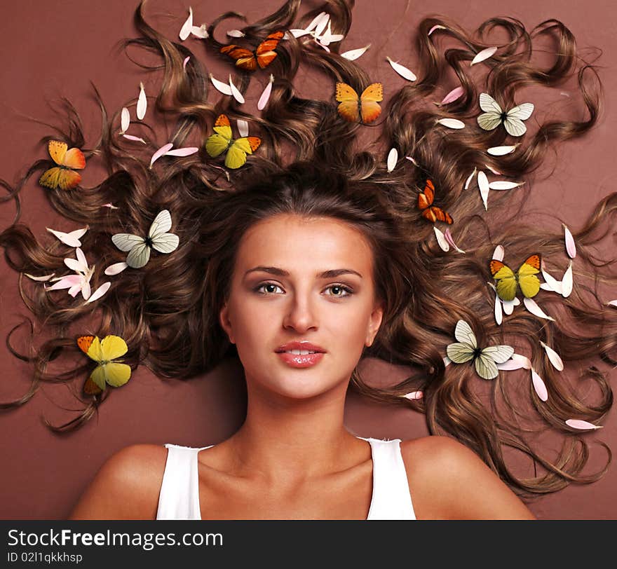 Beautiful woman with petals and butterflies in her hair. Beautiful woman with petals and butterflies in her hair