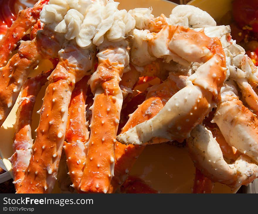 Boiled paws of the crab put on plate in the manner of background