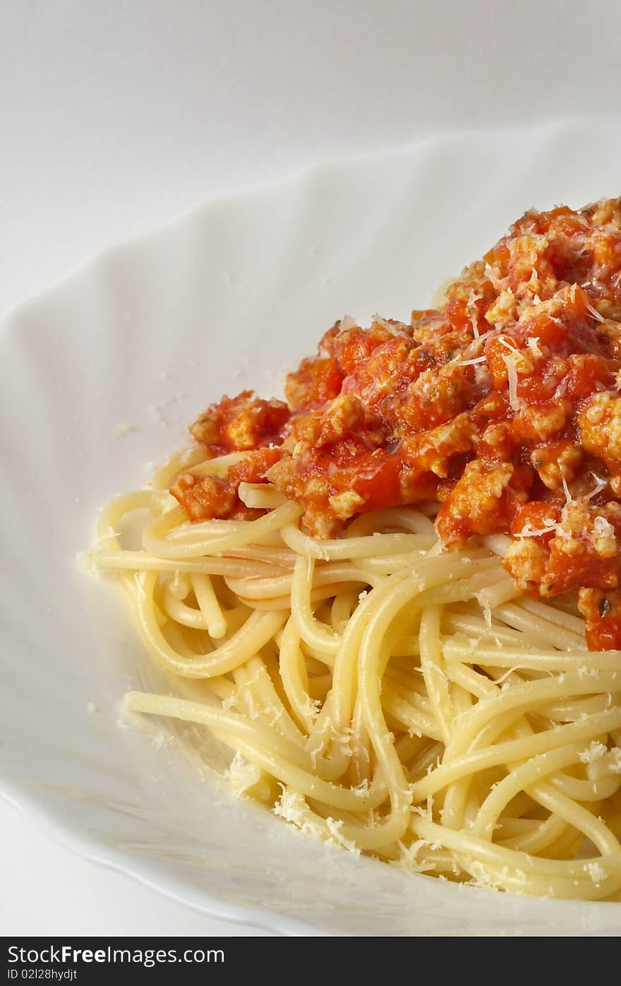 Spaghetti a la Bolognese in the white plate over grey gradient background