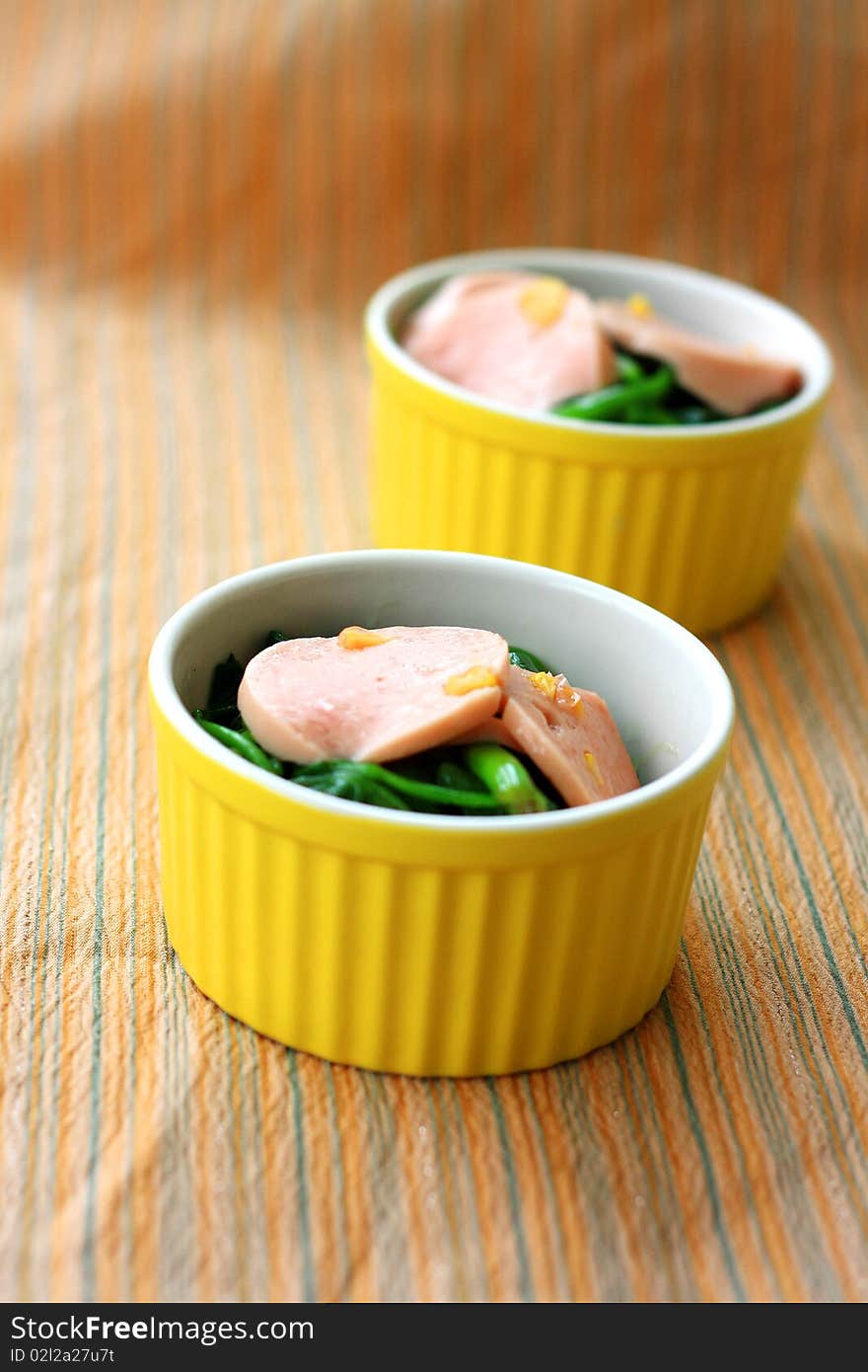 Two bowls of Chinese cuisine, including vegetable and ham.Focus across the middle of image. Two bowls of Chinese cuisine, including vegetable and ham.Focus across the middle of image.