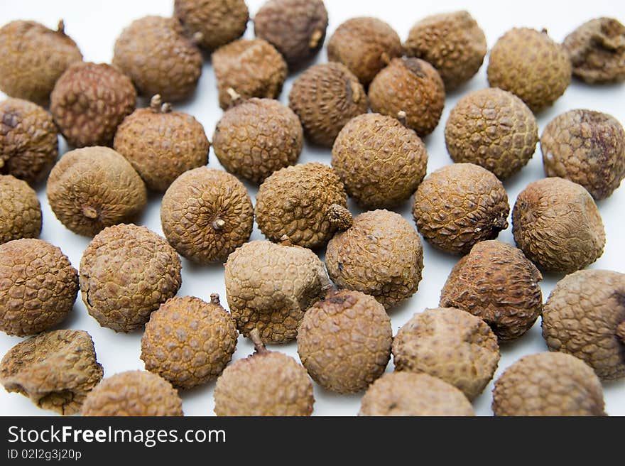 Many dried litchi on white