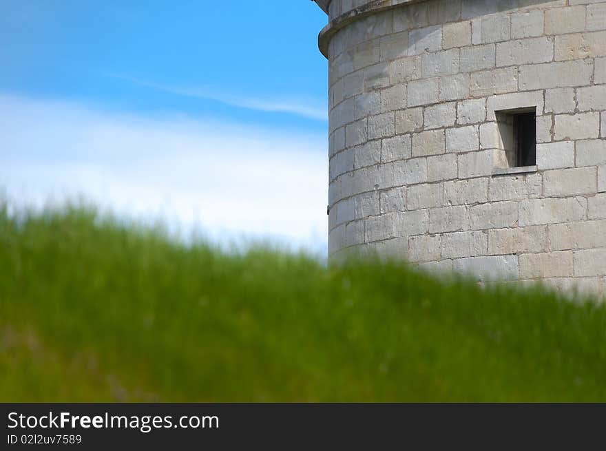 Kuressaare castle tower with blue sky in background and green grass in foreground (Saarema, Estonia)