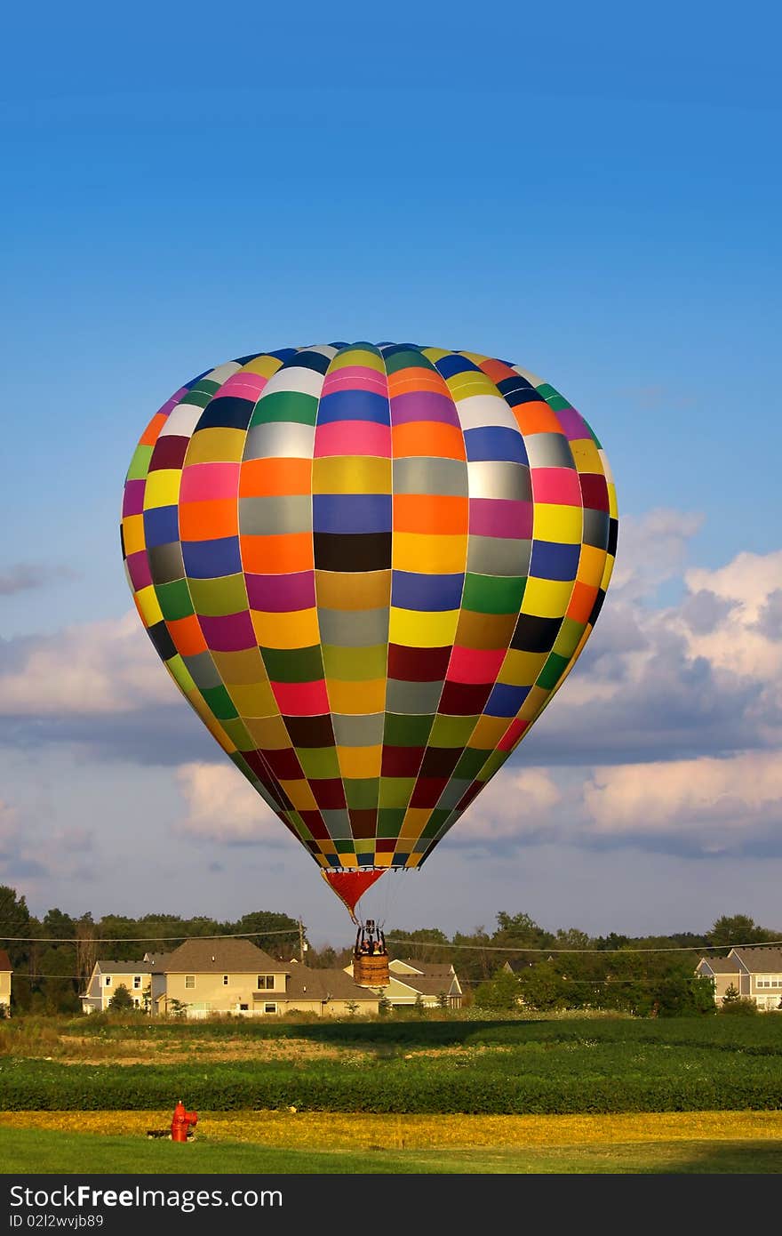 Hot air balloon flying very low near the homes