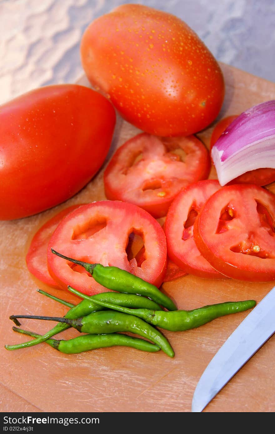 Cut Tomatoes , Onions and green chillies on cutting board. Cut Tomatoes , Onions and green chillies on cutting board