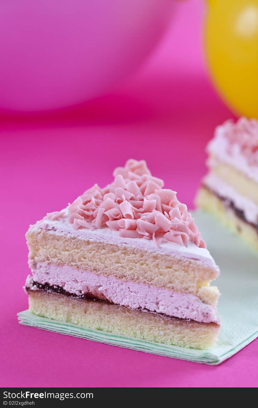 Close up of fresh sliced cake on pink table top