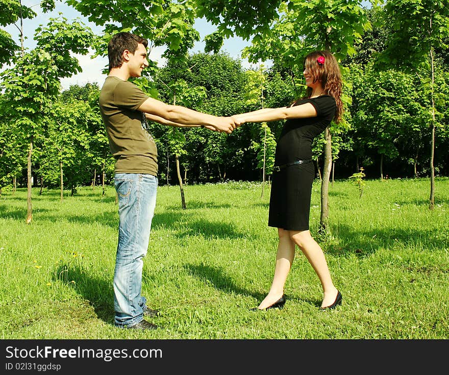 Young man and girl holding for hands outdoor