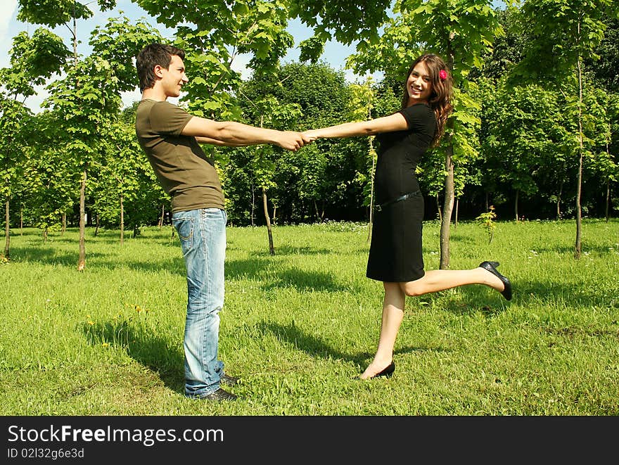 Young man and girl holding for hands outdoor summer time