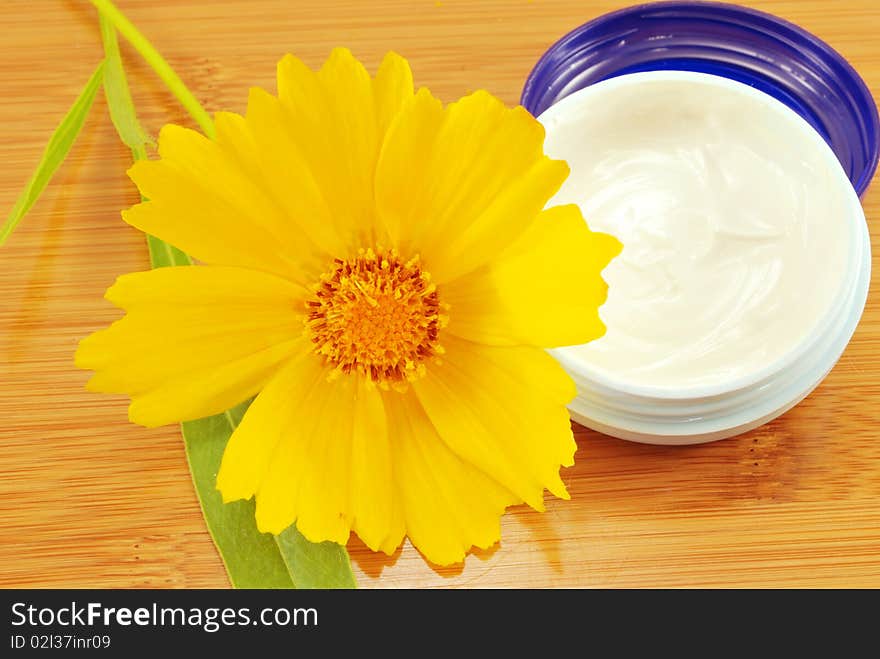 Hydrating cream and a yellow daisy