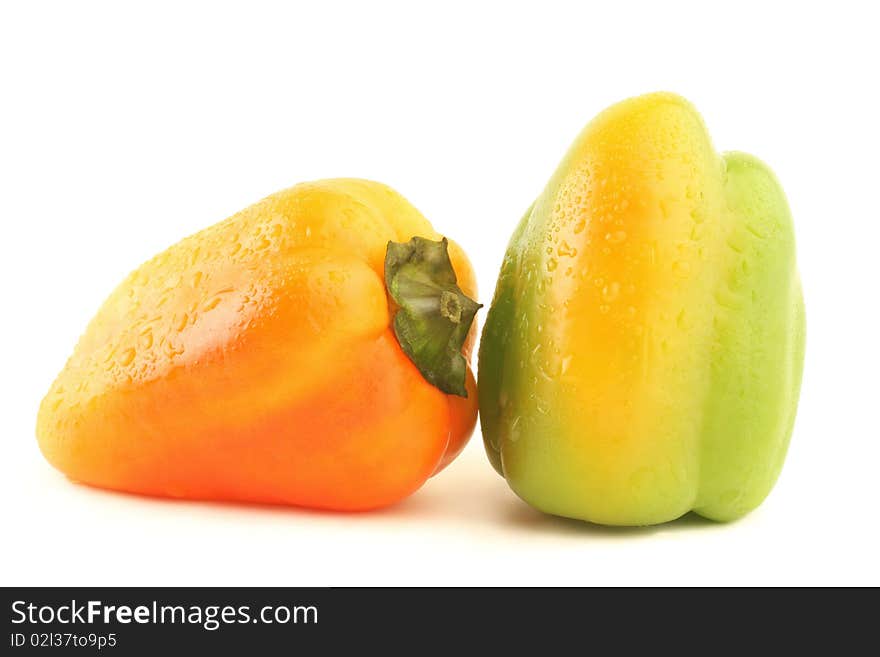 Sweet pepper. Green and orange fresh pepper with drops of water isolated on white background. Sweet pepper. Green and orange fresh pepper with drops of water isolated on white background