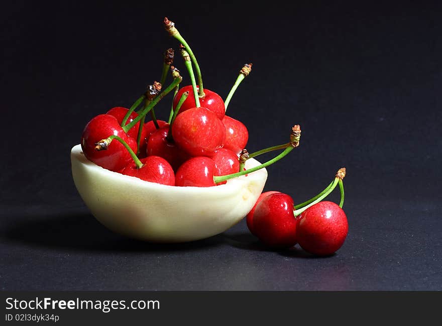 Cherry and  muskmelon in a black backgrounds.