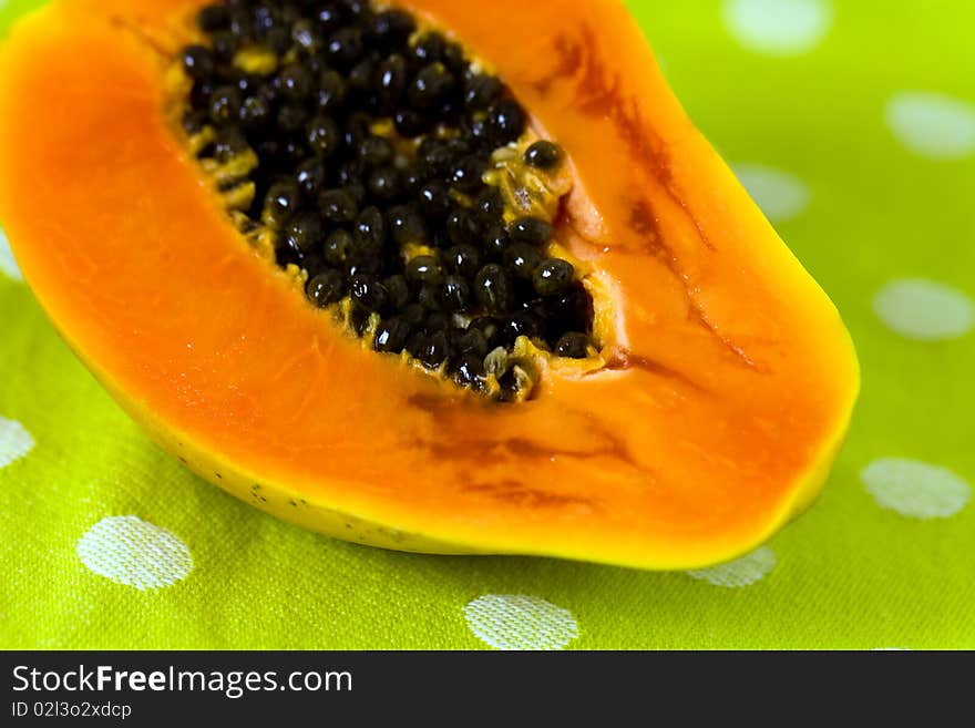 Cut up papaya fruit on green background