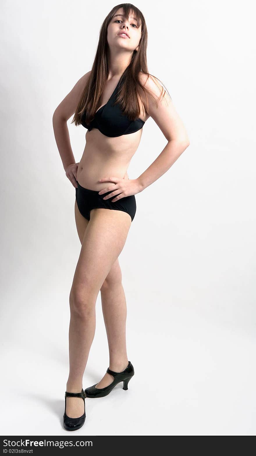 A portrait of a curvy young model in a black bikini and black heels. A portrait of a curvy young model in a black bikini and black heels