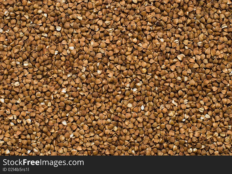 Close-up buckwheat cereal brown background. Close-up buckwheat cereal brown background