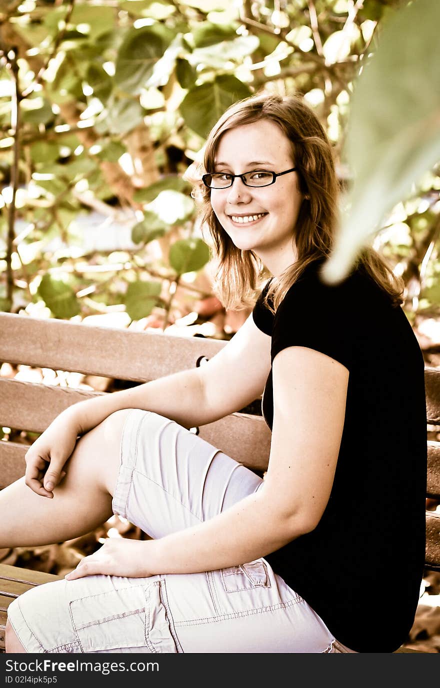 Portrait of a young girl sitting on a bench. Portrait of a young girl sitting on a bench