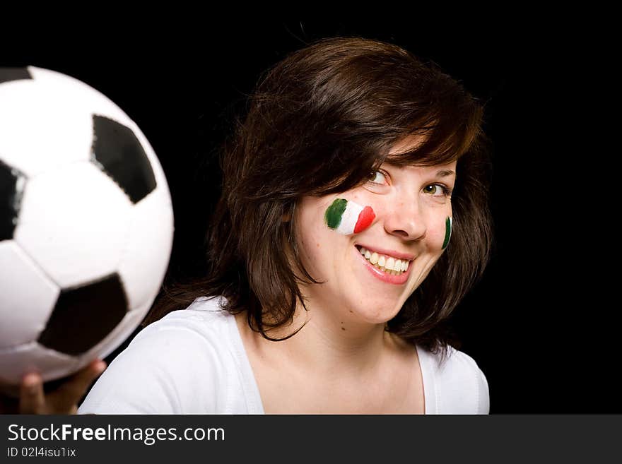 Young happy female with italian flags painted on her cheeks, holds soccer ball in front of her, studio isolated shoot on black background. Young happy female with italian flags painted on her cheeks, holds soccer ball in front of her, studio isolated shoot on black background