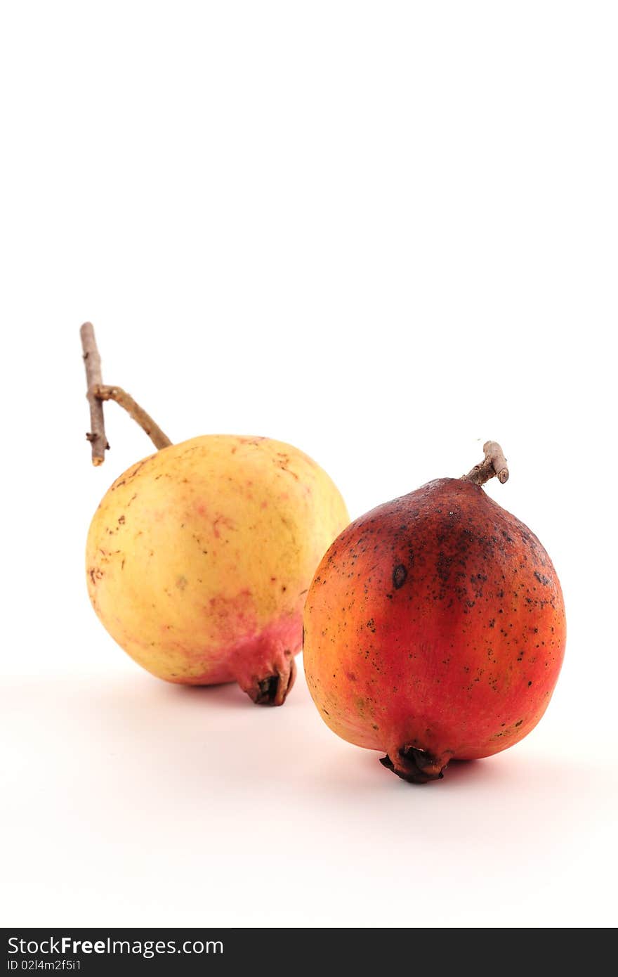 Two pomegranates are on a white background.