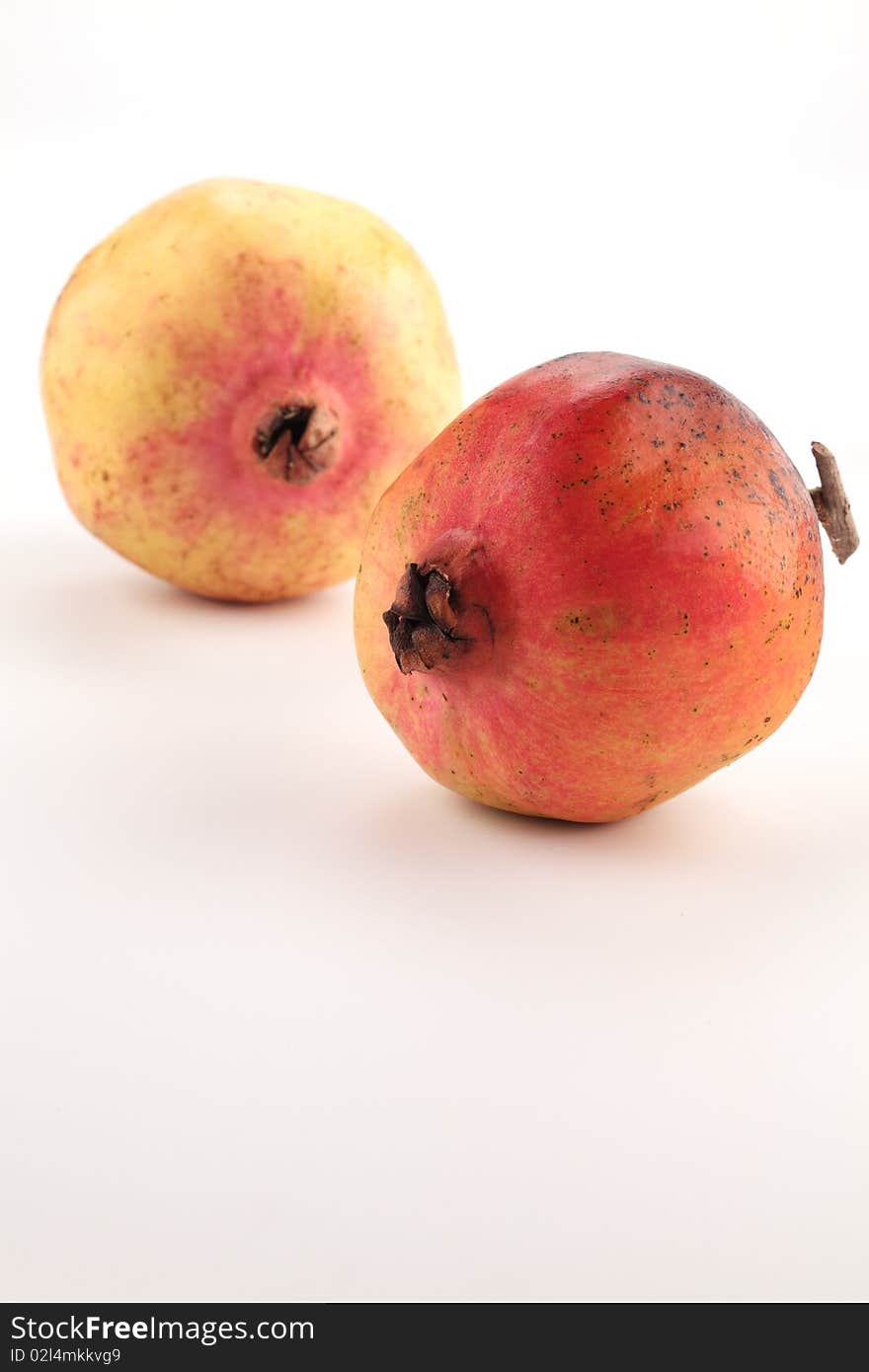 Freckles on pomegranates cheek. They are on white background.