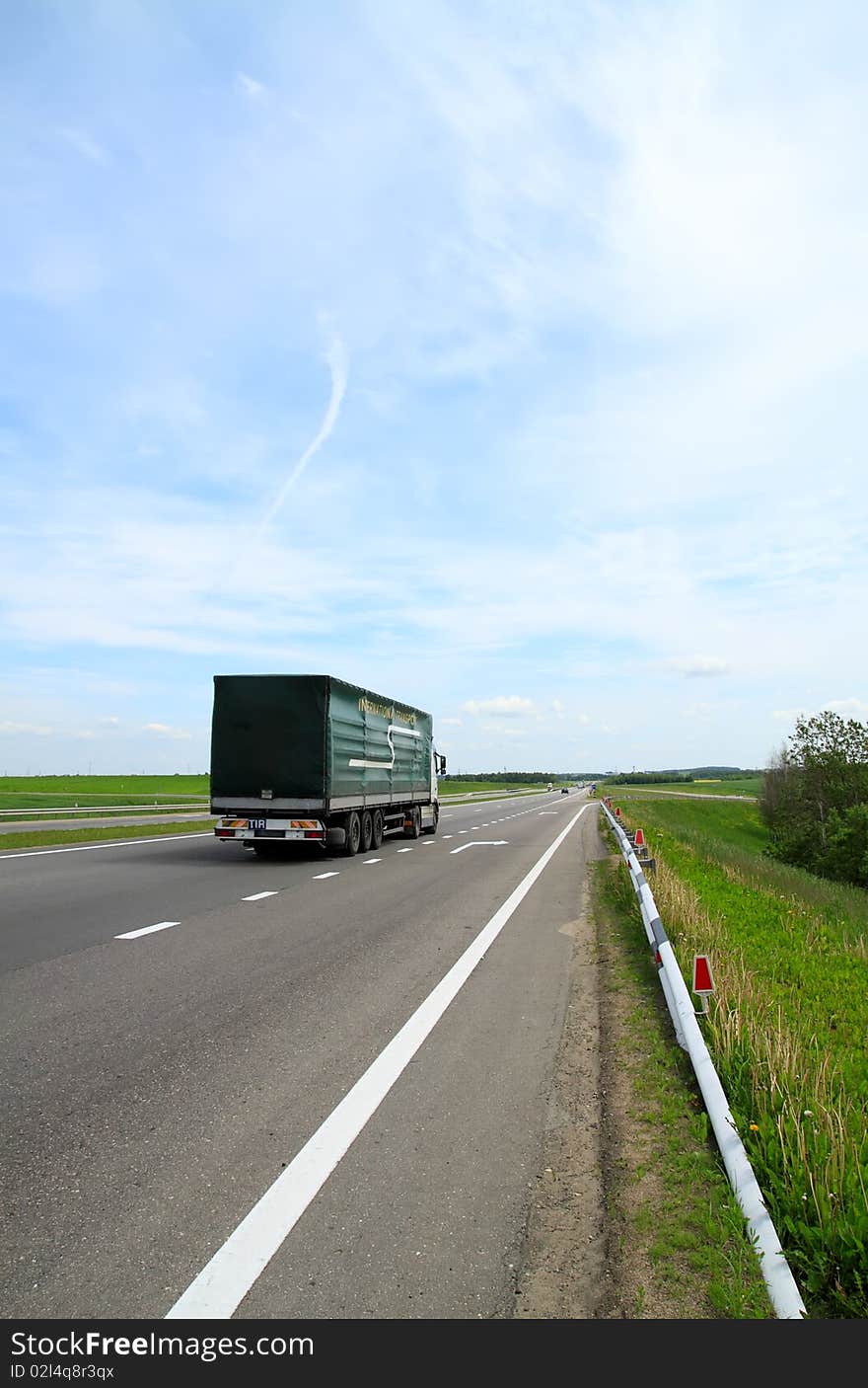 Motorway, with cars going on it, a grass and the blue sky. Motorway, with cars going on it, a grass and the blue sky