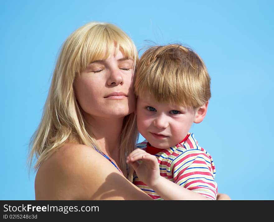 Mum with the small son on hands on a background of the dark blue sky. Mum with the small son on hands on a background of the dark blue sky