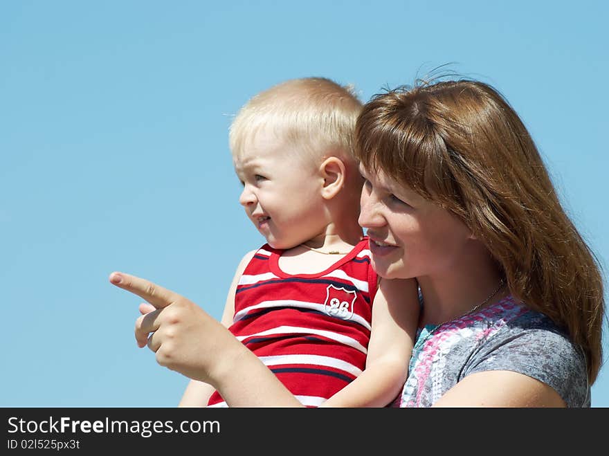 Mum with the small son on hands on a background of the dark blue sky. Mum with the small son on hands on a background of the dark blue sky