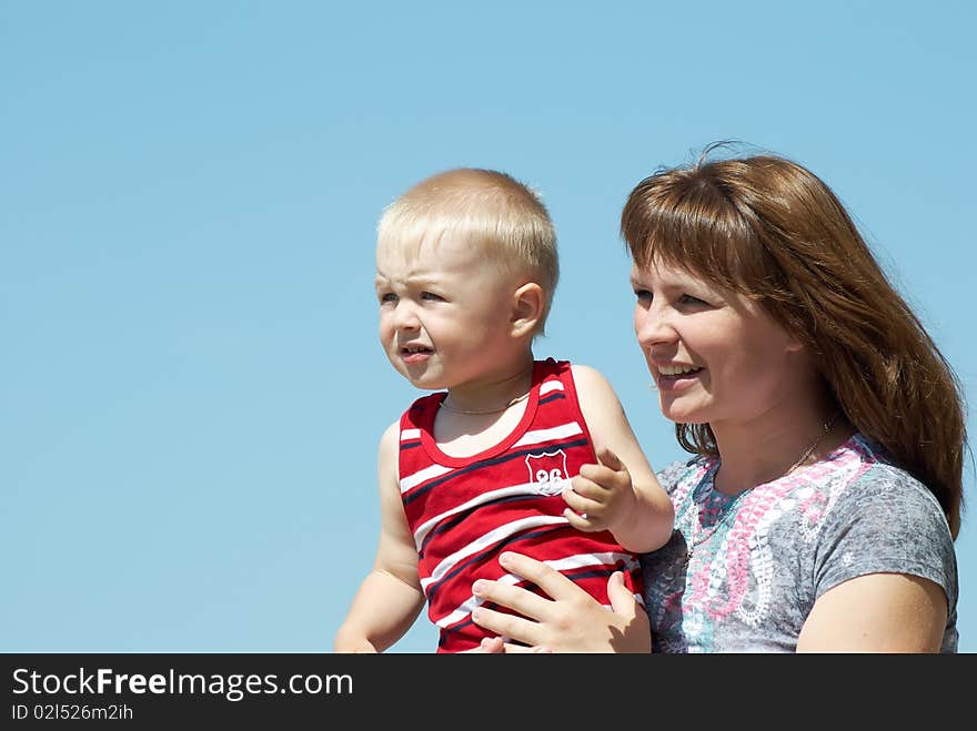 Mum with the small son on hands on a background of the dark blue sky. Mum with the small son on hands on a background of the dark blue sky