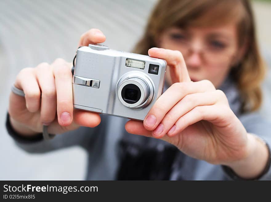 The girl holds the camera in hands