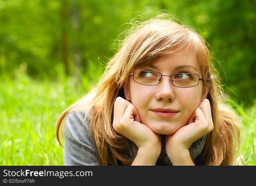 The young girl,  lays on a green grass, in park